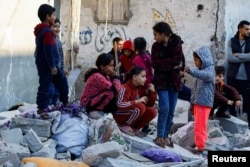 جنوبی غزہ میں ایک مکان پر اسرائیلی حملےکے بعد فلسطینی بچے ملبے کے سامنے ، فوٹو رائٹرز 29دسمبر 2023