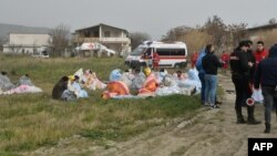 کشتی کے حادثے میں زندہ بچ جانے والے غیر قانونی تارکین وطن اٹلی کے جنوبی ساحلی علاقے میں سردی سے بچنے کے لیے کمبل لپیٹے ہوئے ہیں۔ قریب ہی سرحدی محافظ اور ریسکیو ورکر کھڑے ہیں۔ 26 فروری 2023