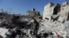 فائل فوٹو: ناصر الواکہ 9 فروری 2023 کو شام کے باغیوں کے زیر قبضہ قصبے جنداریس میں 6 فروری کے زلزلے میں تباہ شدہ اپنے گھر کے ملبے پر کھڑا ہے۔