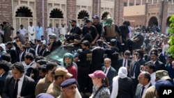 فائل فوٹو: پاکستان کے سابق وزیر اعظم عمران خان اور ان کی اہلیہ بشریٰ بی بی کو 15 مئی 2023 کو لاہور، پاکستان میں عدالت میں پیشی کے بعد سیکیورٹی ایک گاڑی میں لے جا رہی ہے۔