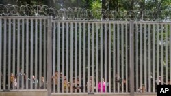پولینڈ کی سرحدی دیوار کے ساتھ پھنسے تارکینِ وطن۔ فوٹو اےپی 28 مئی 2023