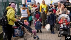 یوکرینی مہاجرین کا ایک قافلہ پولینڈ کے شہر مدیکا میں داخل ہوتے ہوئے۔ 30 مارچ 2022ء
