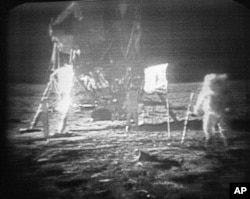 دنیا کے پہلے انسان نیل آرمسٹرانگ کی چاند کی سطح پر اترنے کی پہلی تصویر۔ پس منظر میں چاند گاڑی اترنے کے باعث اٹھنے والی دھول نظر آ رہی ہے۔۔ 20 جولائی 1969