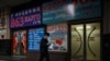 بیجنگ کی ایک سڑک پر ایک شخص 'شپنگ کارگو' کے اشتہار والی ایک عمارت کے سامنے سے گزر رہا ہے۔ 4 مارچ، 2022ء 