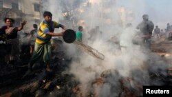 Cư dân địa phương cố gắng dập tắt đám cháy tại khu ổ chuột ở Kolkata, ngày 26/2/2013.
