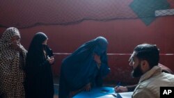 افغان خواتین خوراک کے عالمی ادارے سے امدادی رقم وصول کرنے کے لیے اپنے نام درج کرا رہی ہیں۔ 17 نومبر، 2021ء (فائل فوٹو)