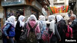 دمشق کے قدیم حصے میں سکول کی طالبات ایک اسٹور سے خریداری کے لیے آئی ہیں۔ تجزیہ کاروں کا کہنا ہے کہ نئی امریکی پابندیوں کے اثرات شام کے ہر شعبے پر پڑیں گے۔